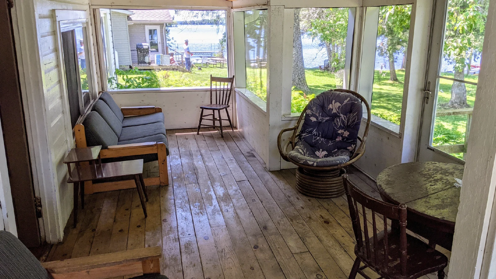 Pigeon Lake Resort Cottage three screened-in porch with seating and lake view.